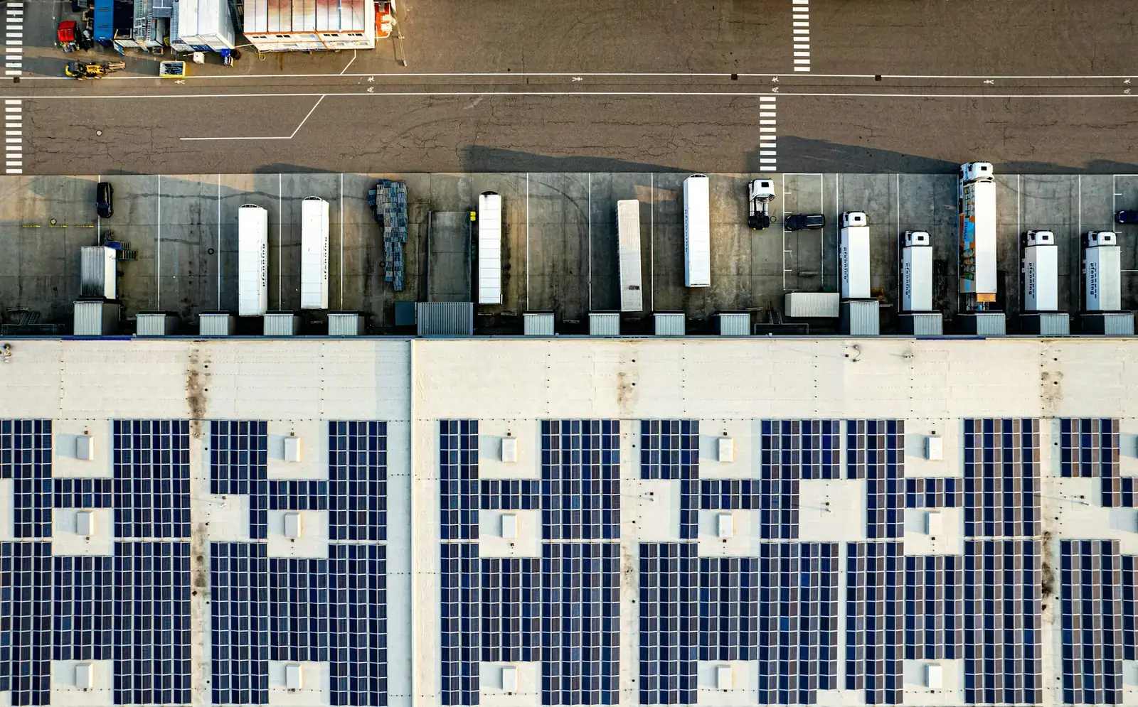 Aerial view of a commercial warehouse roof covered with solar panels